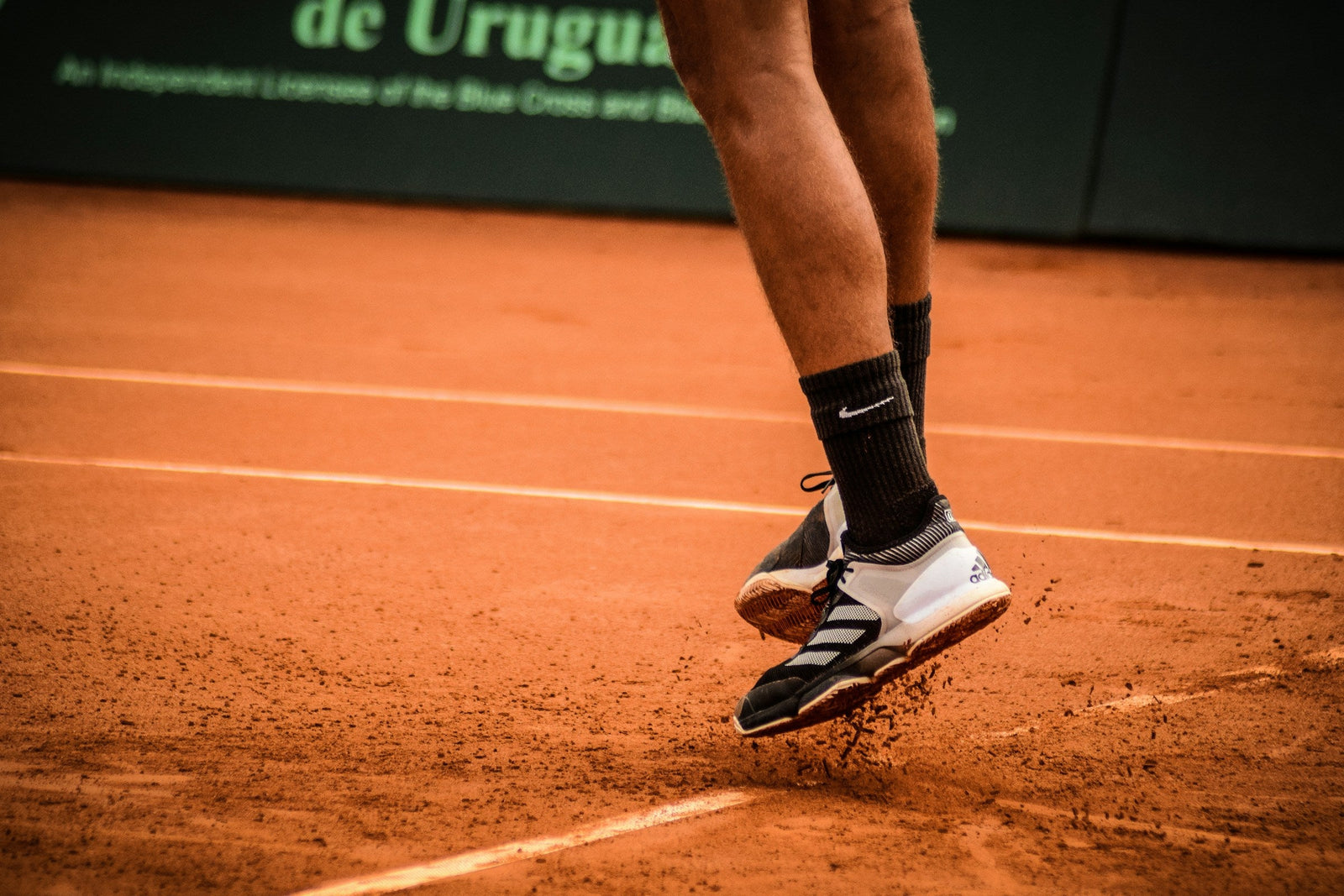 man springend op tennisveld